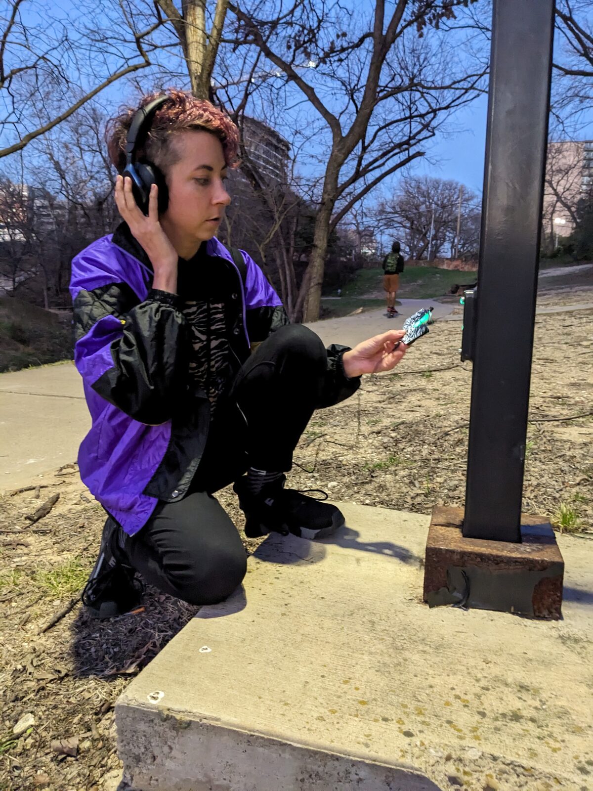 Explorer listening to a streetlight pole outdoors