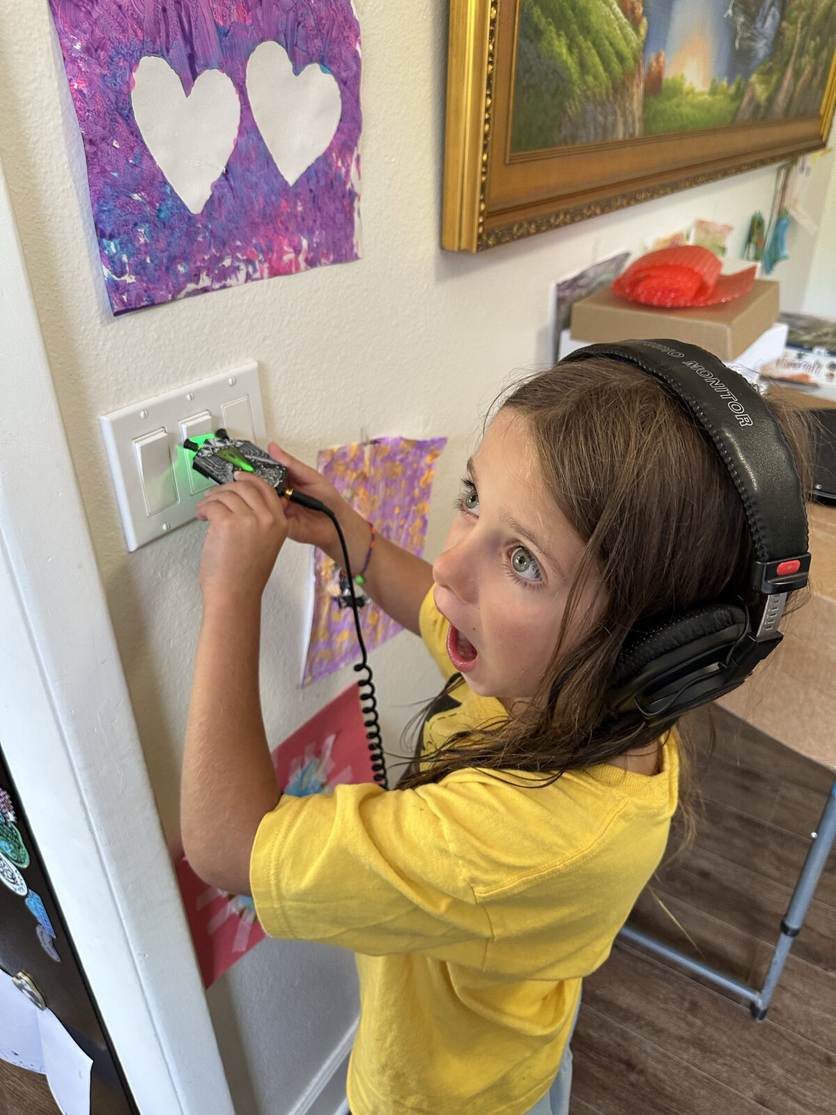 Kid listening to EMF from a wall outlet with the badge